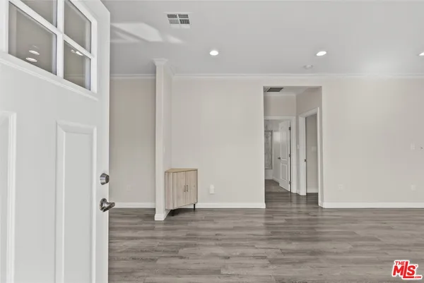 a view of an empty room with wooden floor