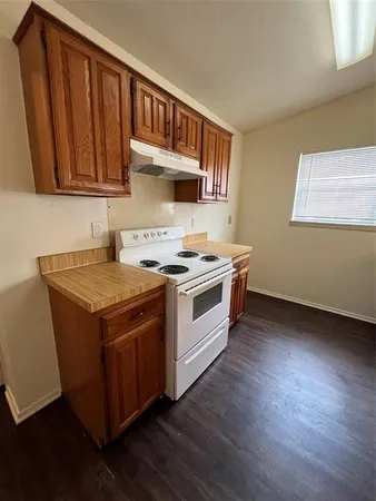 a kitchen with wooden cabinets and a stove top oven