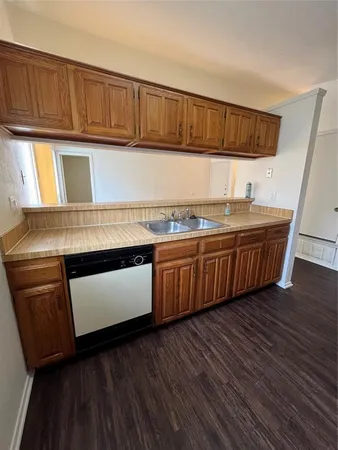 a kitchen with stainless steel appliances granite countertop a sink and wooden cabinets with wooden floors