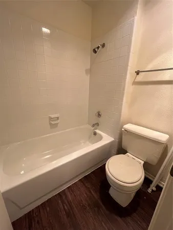 a white toilet sitting next to a bath tub