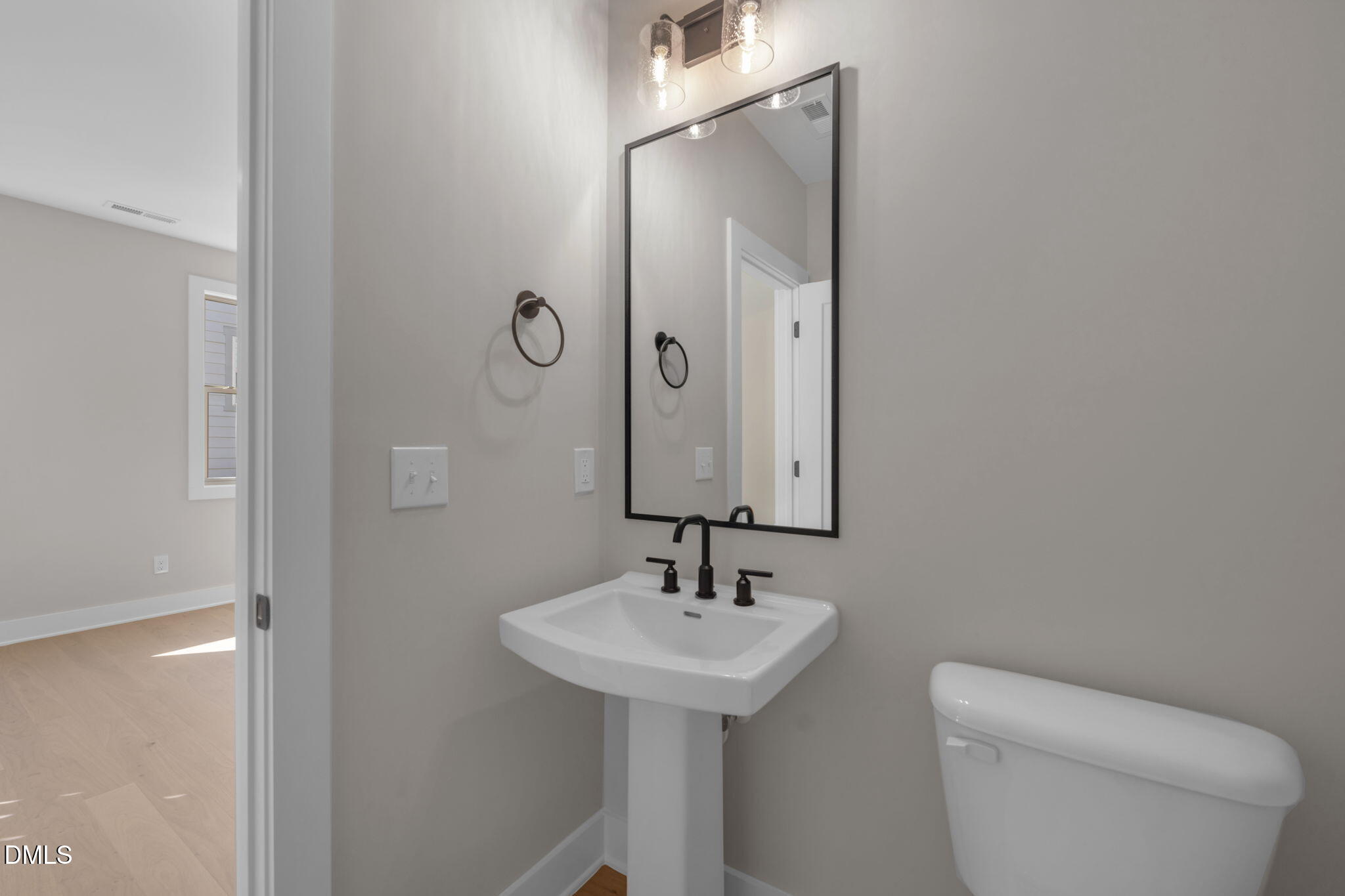 974 Double Helix Road Apex, NC 27523 - Photo 16 of 52 a bathroom with a sink a toilet and mirror