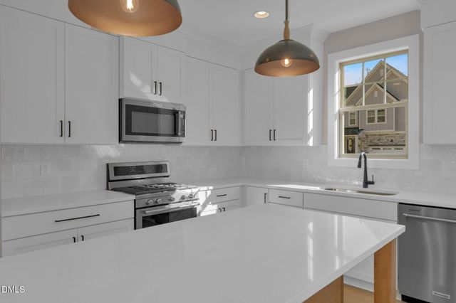 a kitchen with a sink a microwave and cabinets