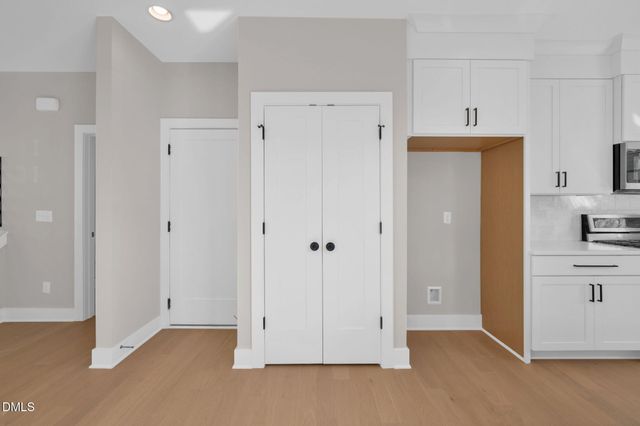 a view of a kitchen with white cabinets