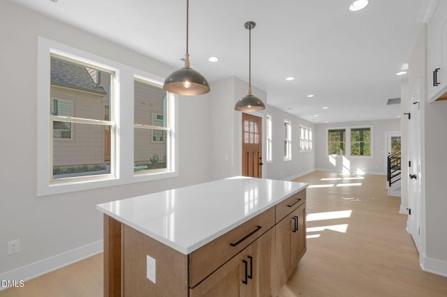 a kitchen with a stove a refrigerator a sink dishwasher with a dining table and chairs