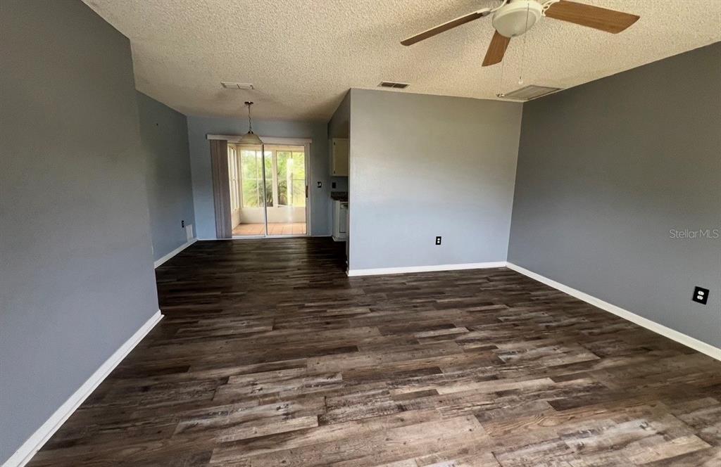 7670 Southwest 112th Lane Ocala, FL 34476 - Photo 3 of 16 an empty room with wooden floor window and ceiling fan