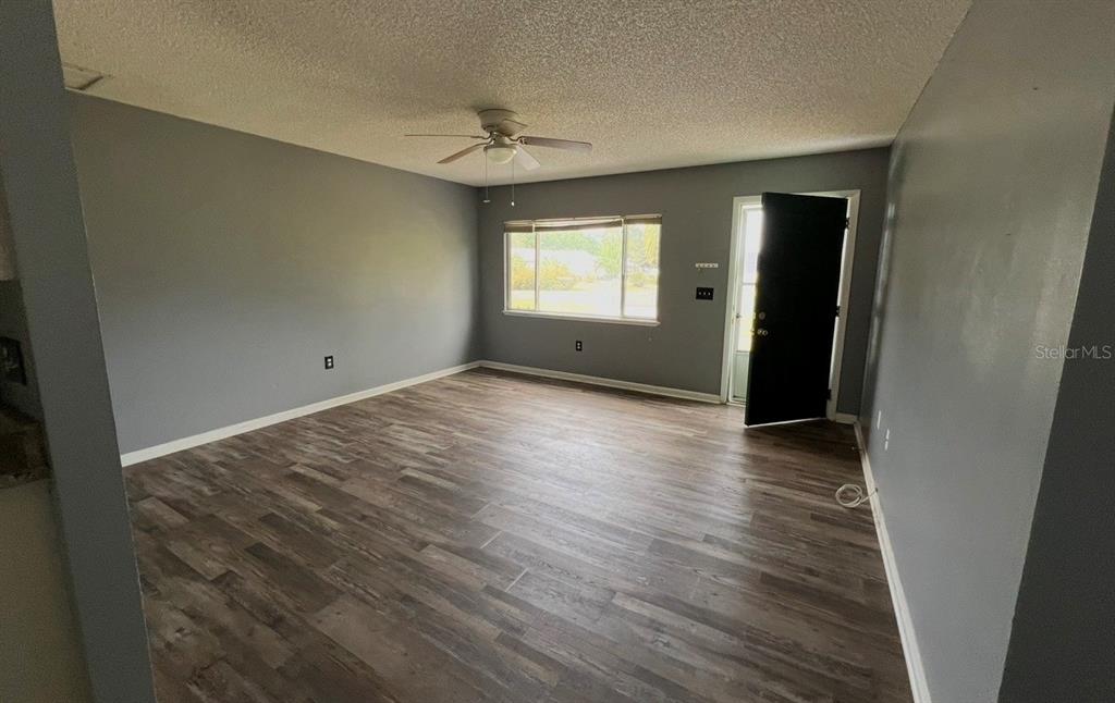 7670 Southwest 112th Lane Ocala, FL 34476 - Photo 6 of 16 an empty room with wooden floor and windows