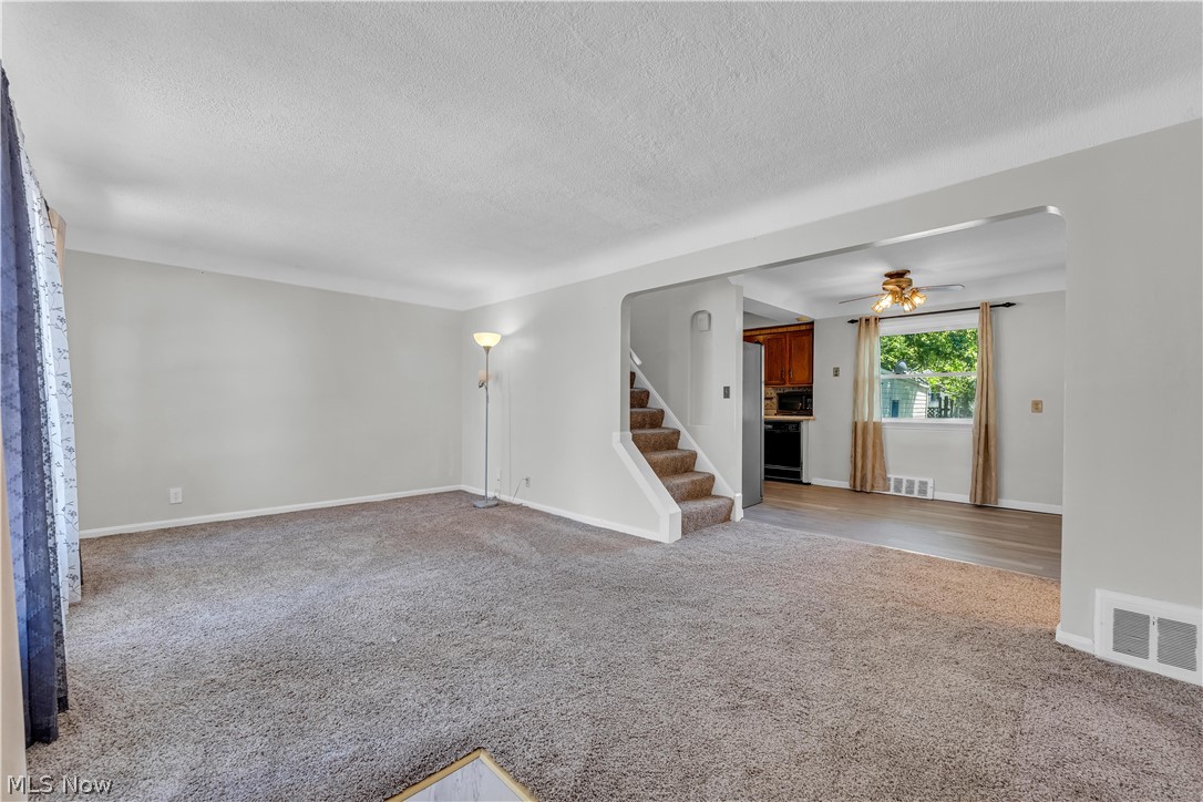 3842 Wallingford Road South Euclid, OH 44121 - Photo 8 of 31 Unfurnished living room featuring ceiling fan, a textured ceiling, and carpet flooring