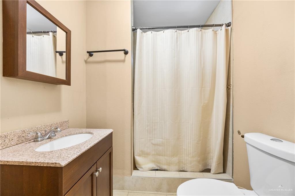 304 South 27th Street McAllen, TX 78501 - Photo 13 of 21 a bathroom with a granite countertop sink and a mirror