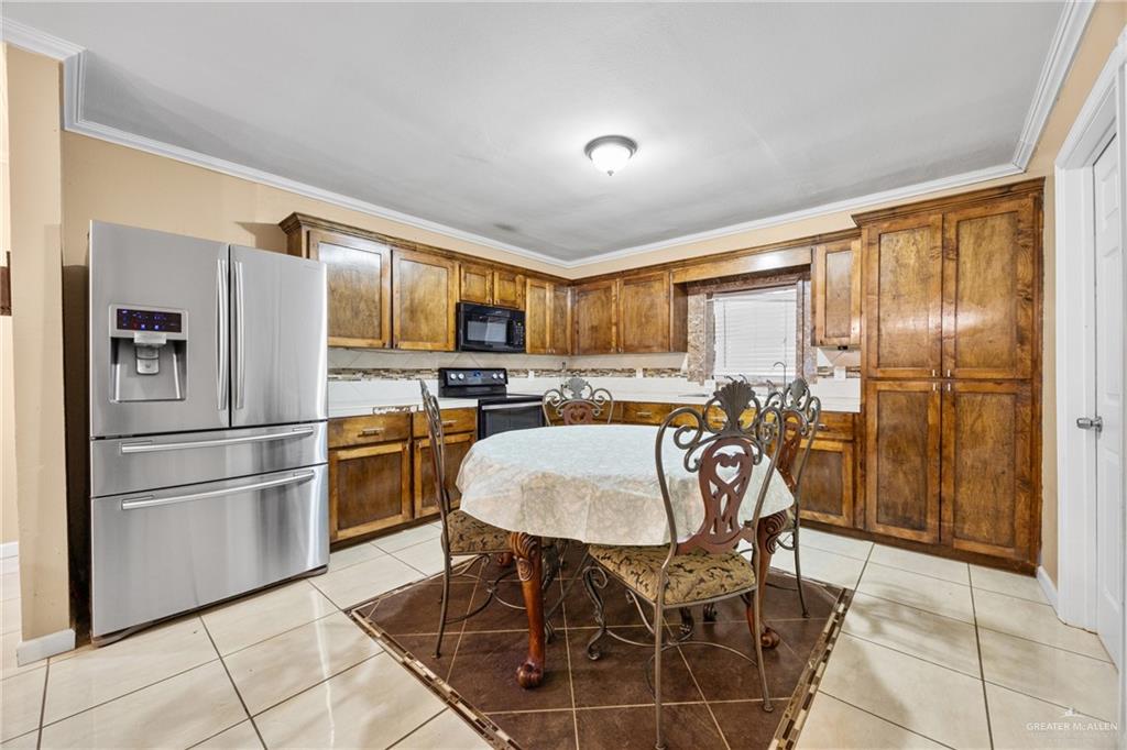 304 South 27th Street McAllen, TX 78501 - Photo 5 of 21 a kitchen with stainless steel appliances granite countertop a refrigerator a stove a sink dishwasher with a dining table and chairs