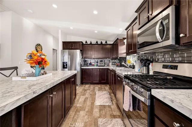 a kitchen with stainless steel appliances granite countertop a stove a sink and a microwave