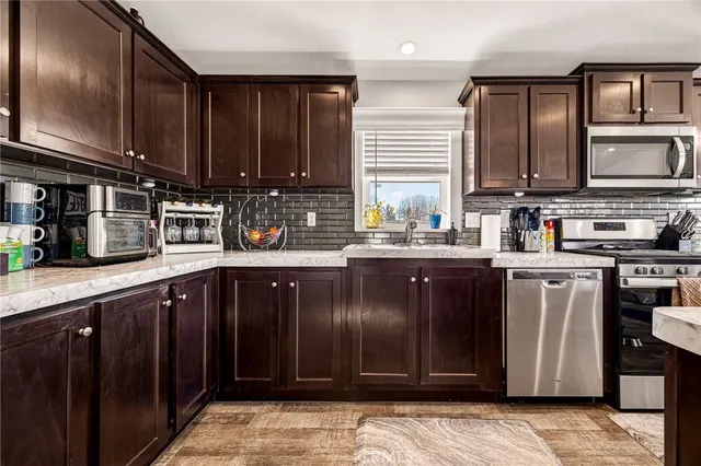 a kitchen with stainless steel appliances granite countertop a sink stove and cabinets