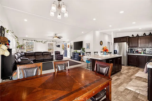 a kitchen with stainless steel appliances granite countertop a stove refrigerator and a view of living room