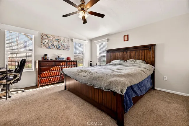 a bed sitting in a spacious bedroom next to a window