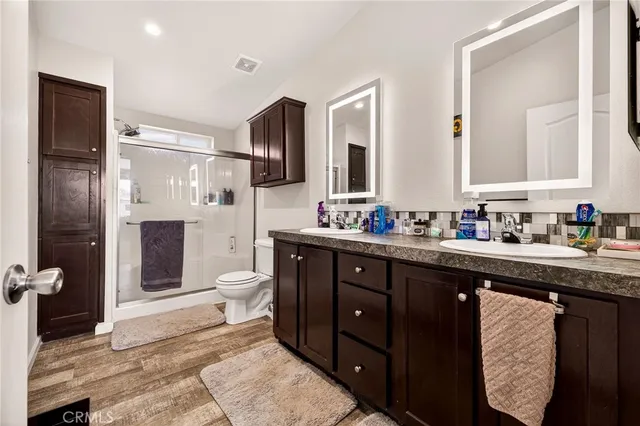 a spacious bathroom with a granite countertop sink toilet and shower