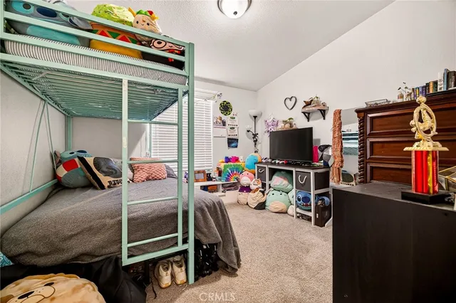 a bedroom with furniture and a flat screen tv