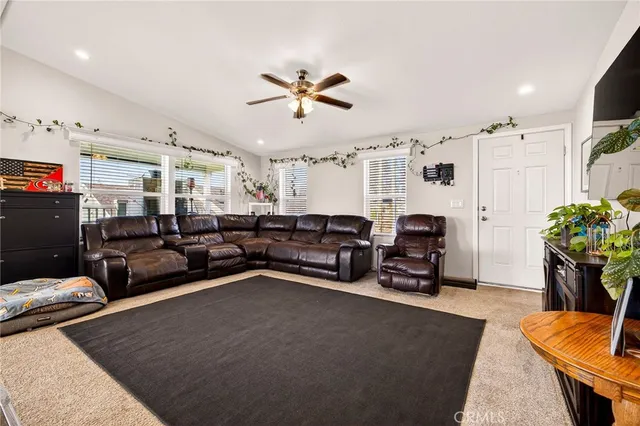 a living room with furniture kitchen view and a chandelier