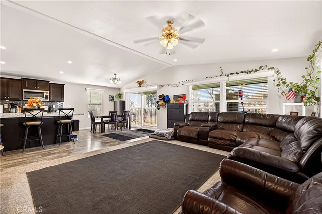 a living room with furniture kitchen view and a flat screen tv