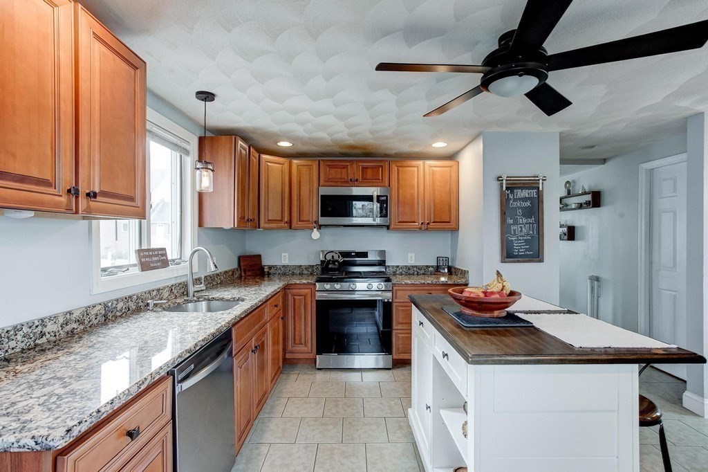 54 Pine Street Stoneham, MA 02180 - Photo 11 of 30 a kitchen with stainless steel appliances granite countertop a sink stove and refrigerator