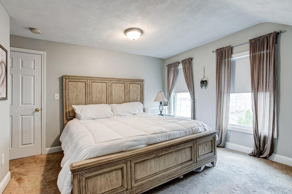 54 Pine Street Stoneham, MA 02180 - Photo 19 of 30 a bed sitting in a spacious bedroom next to a window and a larger closet