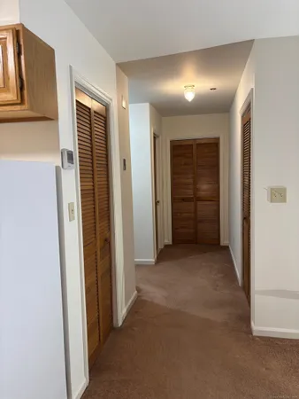 a view of a hallway with an empty room and fire place