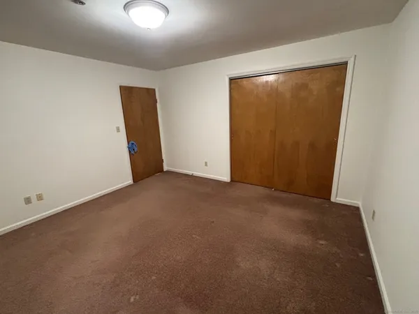 an empty room with closet and mirror