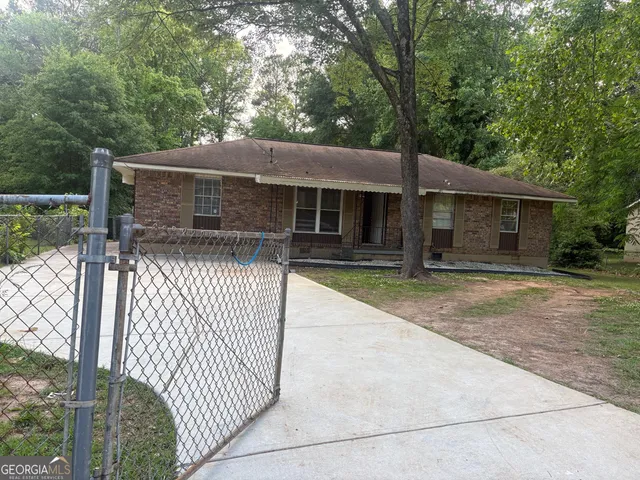 a view of house with backyard and trees