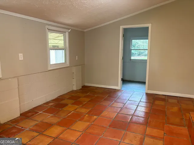 a front view of a house with a garden and trees