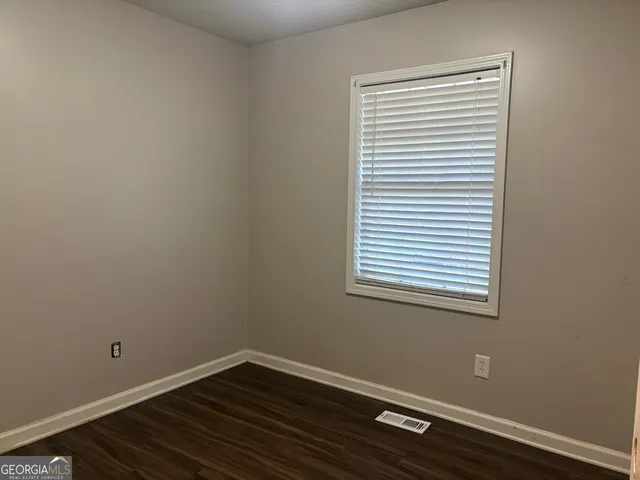 a view of a small space with wooden floor and a window