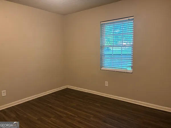 a view of a room with wooden floor and a window