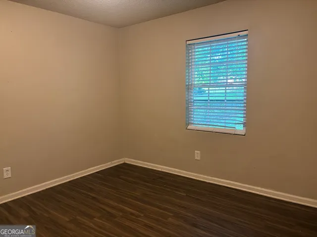 a view of a room with wooden floor and a window