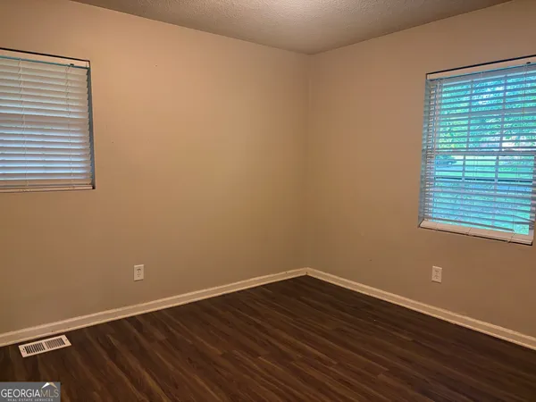a view of a room with wooden floor and a window