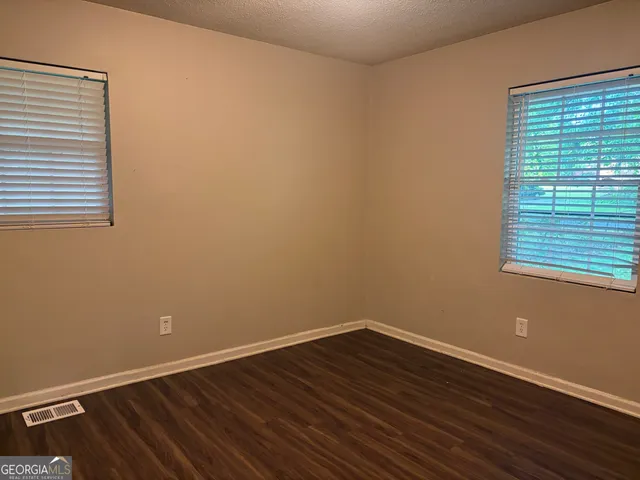 a view of a room with wooden floor and a window