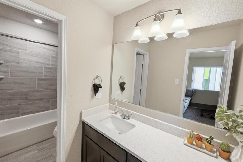 10701 Kestrel Court Waco, TX 76708 - Photo 13 of 37 Bathroom featuring vanity, bathtub / shower combination, and decorative lighting
