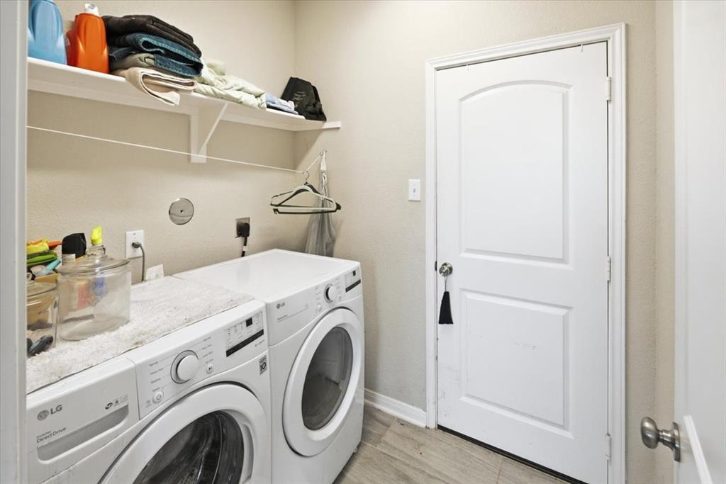 10701 Kestrel Court Waco, TX 76708 - Photo 21 of 37 Laundry area with washing machine and dryer and light wood-look flooring