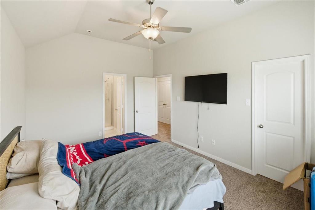 10701 Kestrel Court Waco, TX 76708 - Photo 8 of 37 Bedroom featuring light carpet, ensuite bathroom, vaulted ceiling, and a ceiling fan