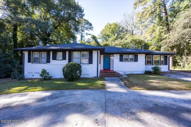 a view of a house with backyard and trees