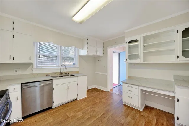 a kitchen with granite countertop a sink cabinets and wooden floor