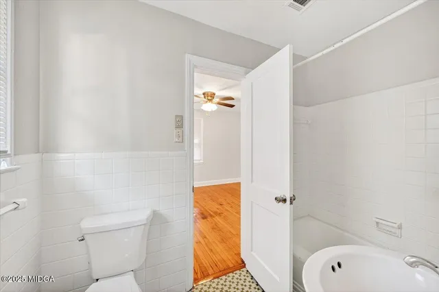a bathroom with a granite countertop toilet and a shower