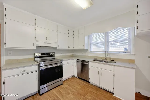 a kitchen with granite countertop white cabinets and white appliances