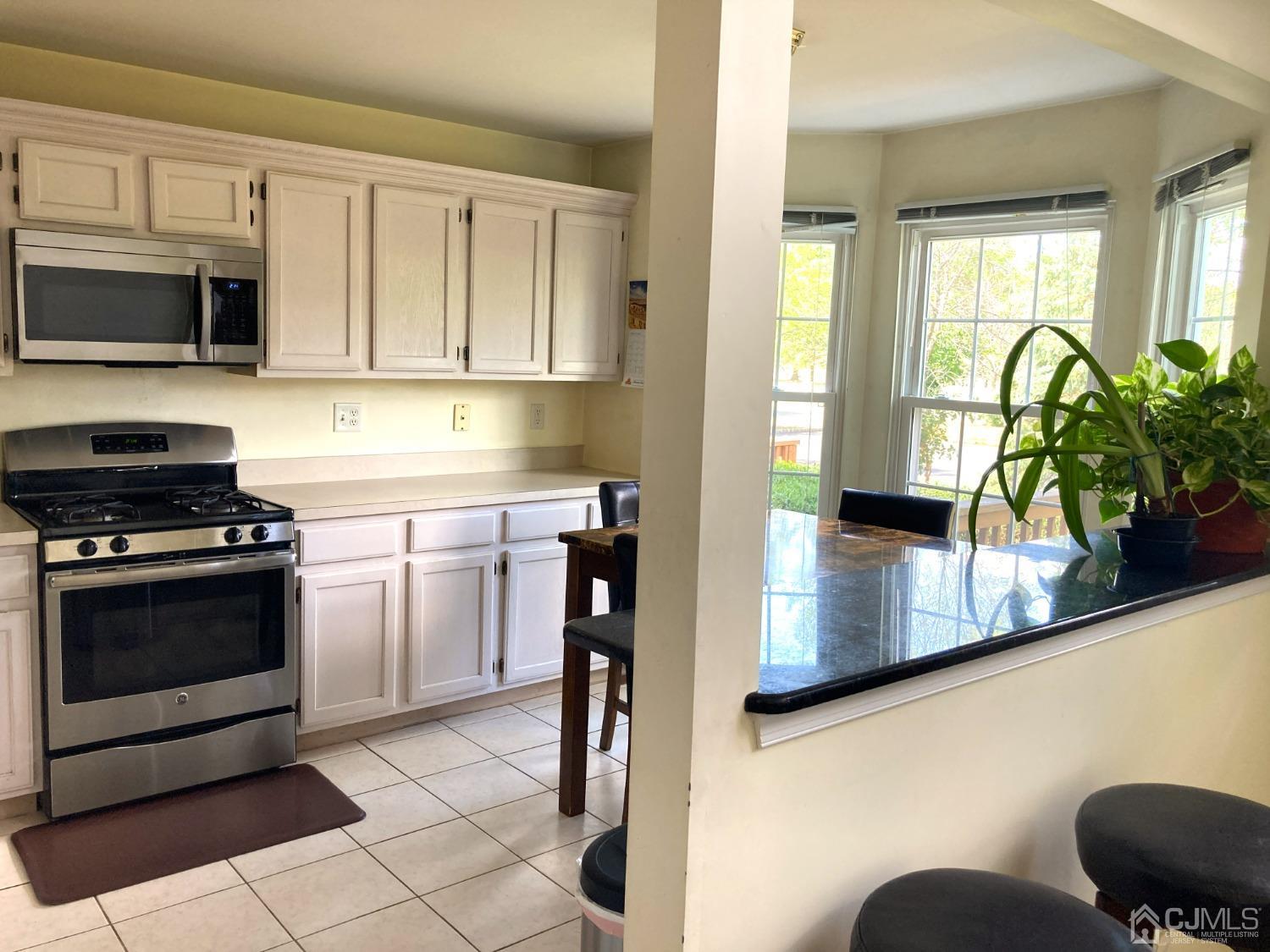 310 Hawthorne Road North Brunswick, NJ 08902 - Photo 20 of 25 a kitchen with stainless steel appliances kitchen island granite countertop a stove a sink and a microwave