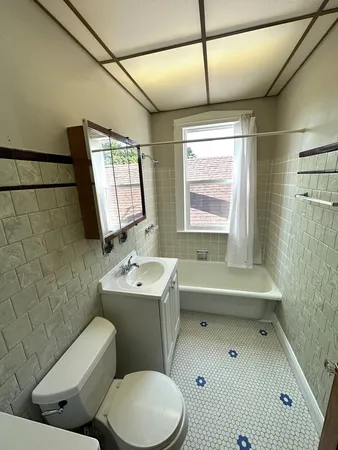 a bathroom with a toilet sink and mirror