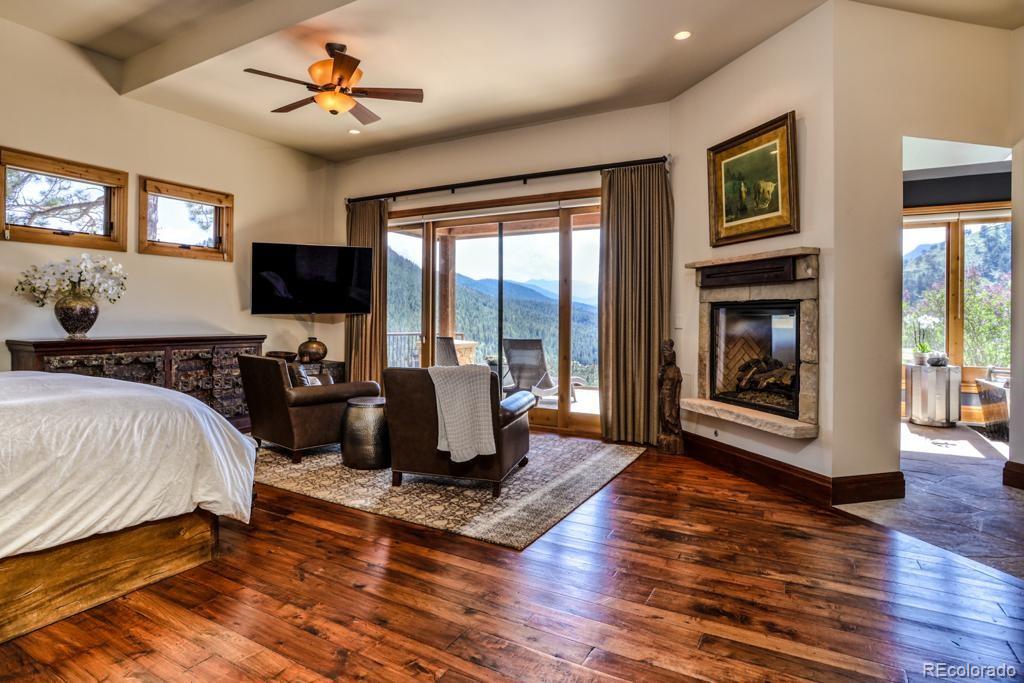 3731 Overlook Trail Evergreen, CO 80439 - Photo 12 of 35 a spacious bedroom with a bed and glass door
