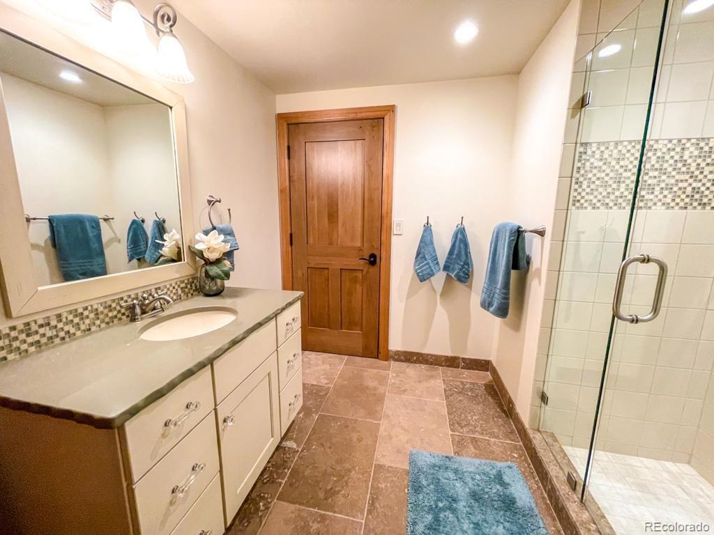 3731 Overlook Trail Evergreen, CO 80439 - Photo 26 of 35 a spacious bathroom with a granite countertop sink and a mirror