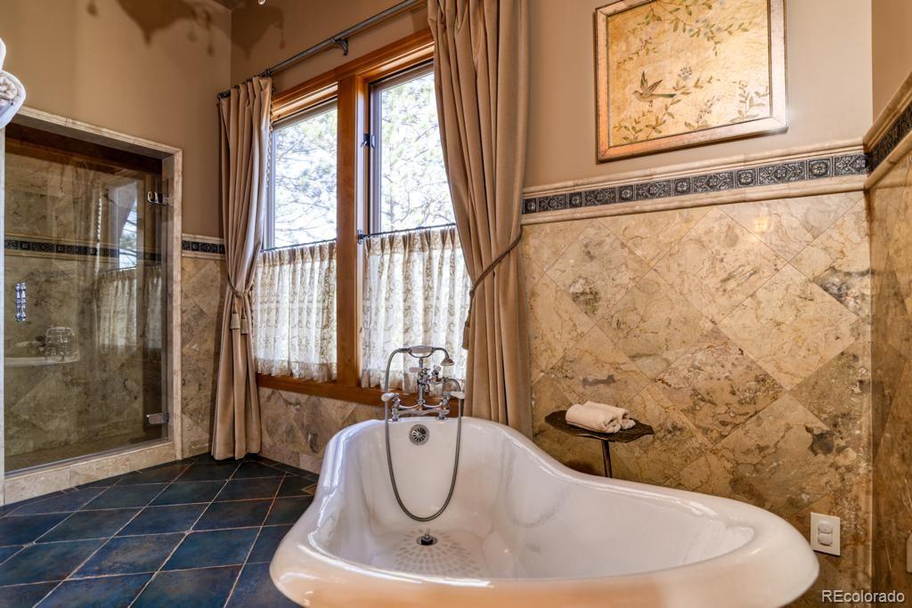 3731 Overlook Trail Evergreen, CO 80439 - Photo 28 of 35 a bathroom with a bathtub and shower
