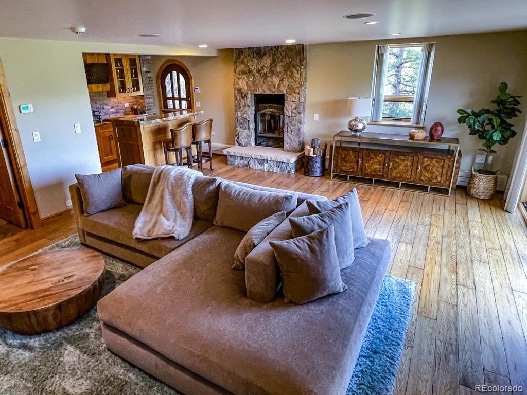 3731 Overlook Trail Evergreen, CO 80439 - Photo 30 of 35 a living room with furniture fireplace and wooden floor