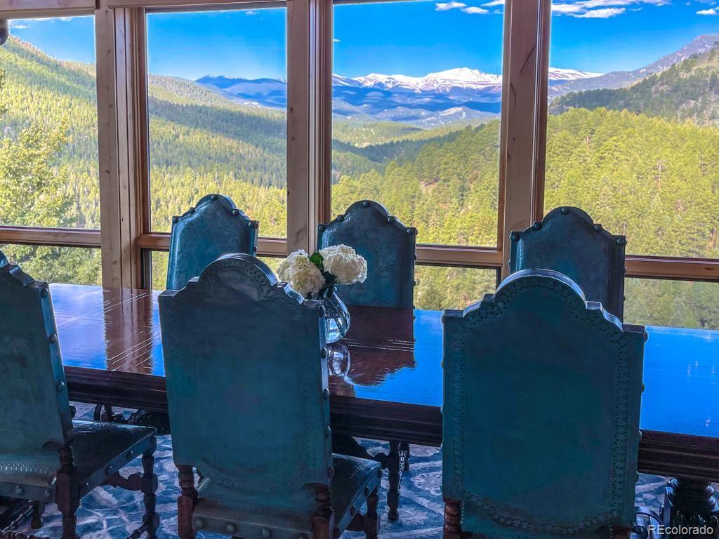 3731 Overlook Trail Evergreen, CO 80439 - Photo 3 of 35 a living room with chairs and a floor to ceiling window