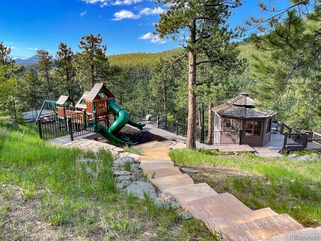 3731 Overlook Trail Evergreen, CO 80439 - Photo 33 of 35 a backyard of a house with table and chairs