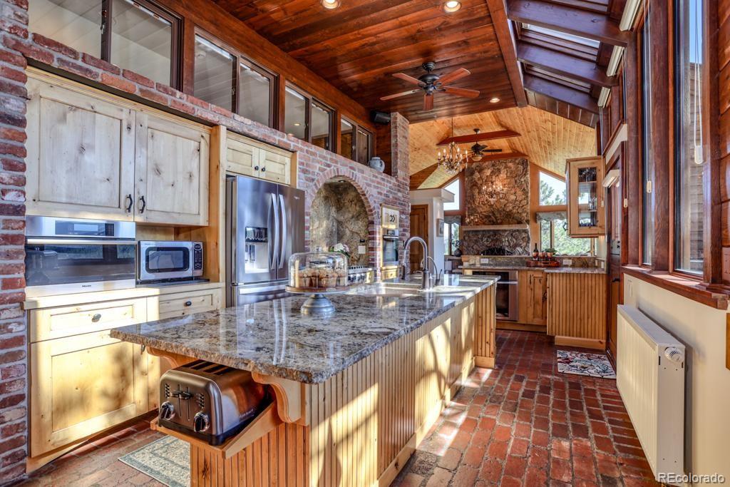 3731 Overlook Trail Evergreen, CO 80439 - Photo 7 of 35 a kitchen with stainless steel appliances granite countertop a stove and a wooden cabinets