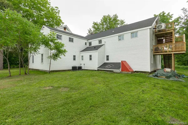 a view of a backyard with plants and a large tree