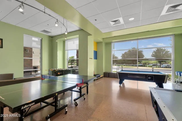 a room with pool table and windows